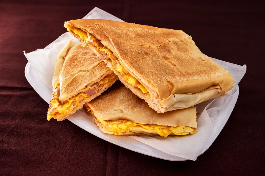 A pressed ham and egg sandwich on paper